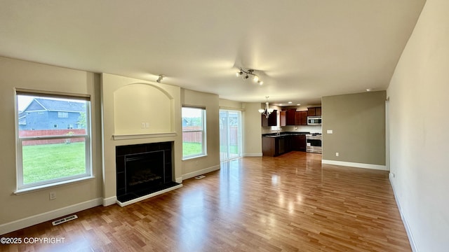 5612 Grand Teton Loop, Anchorage, AK 99502 - unfurnished living room with baseboards, wood finished floors, and a fireplace