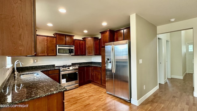 5612 Grand Teton Loop, Anchorage, AK 99502 - kitchen with appliances with stainless steel finishes, a sink, light wood-type flooring, dark stone counters, and recessed lighting