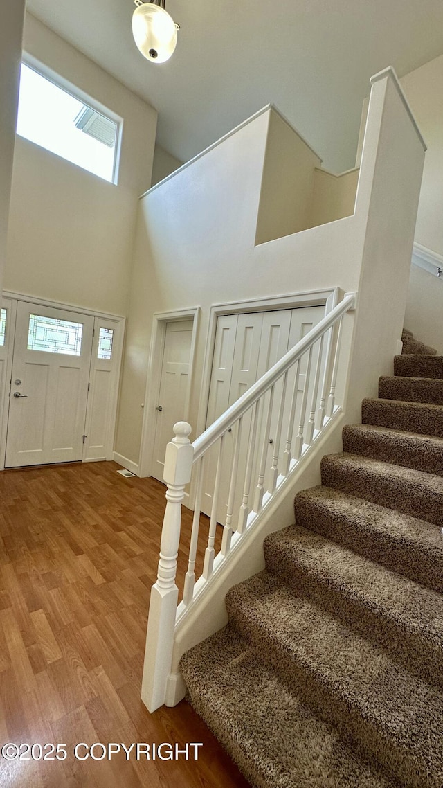 5612 Grand Teton Loop, Anchorage, AK 99502 - entryway featuring a high ceiling, wood finished floors, stairs, healthy amount of natural light, and baseboards