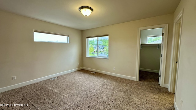 5612 Grand Teton Loop, Anchorage, AK 99502 - unfurnished bedroom featuring baseboards, a spacious closet, carpet flooring, and a closet