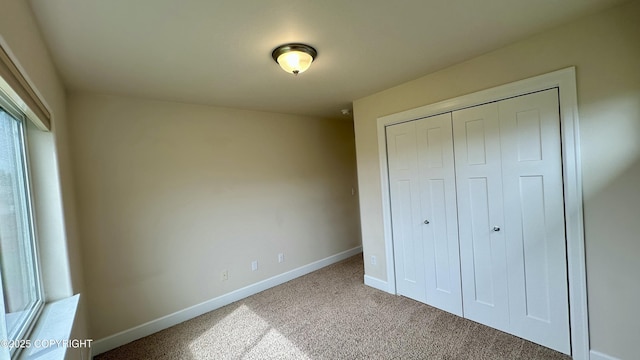5612 Grand Teton Loop, Anchorage, AK 99502 - unfurnished bedroom featuring baseboards, carpet, and a closet