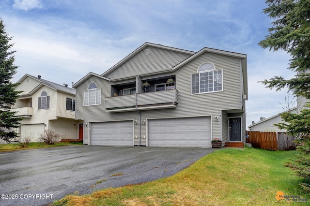 multi unit property featuring an attached garage, asphalt driveway, and a balcony