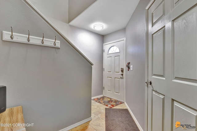 entrance foyer with light tile patterned floors and baseboards