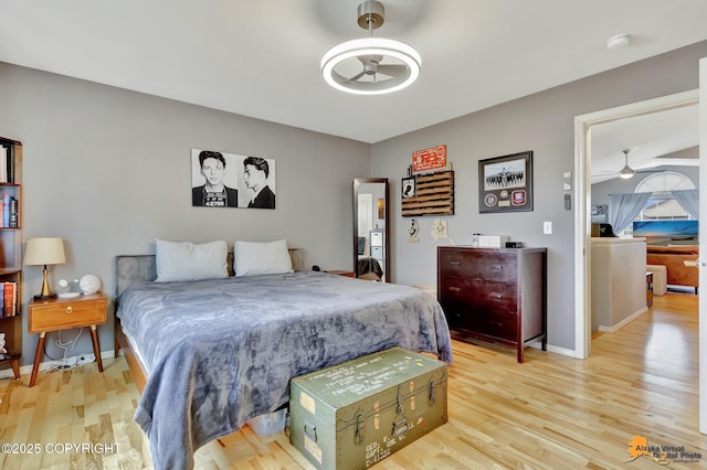bedroom featuring light wood finished floors and baseboards