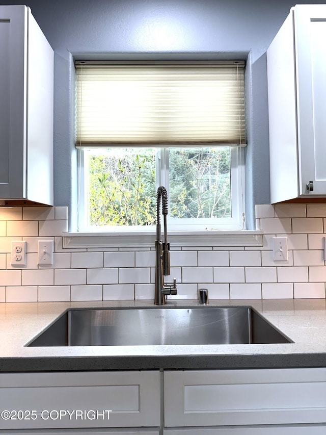 2321 Selief Ln, Kodiak, AK 99615 - kitchen view of a sink, backsplash, white cabinetry, and light stone countertops