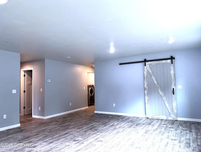 2321 Selief Ln, Kodiak, AK 99615 - unfurnished room with a barn door, wood finished floors, baseboards, and separate washer and dryer