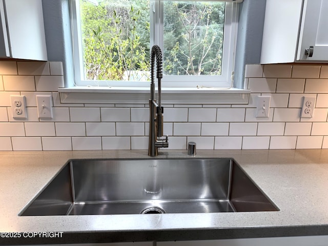 2321 Selief Ln, Kodiak, AK 99615 - kitchen view of a sink, light stone countertops, white cabinets, and decorative backsplash