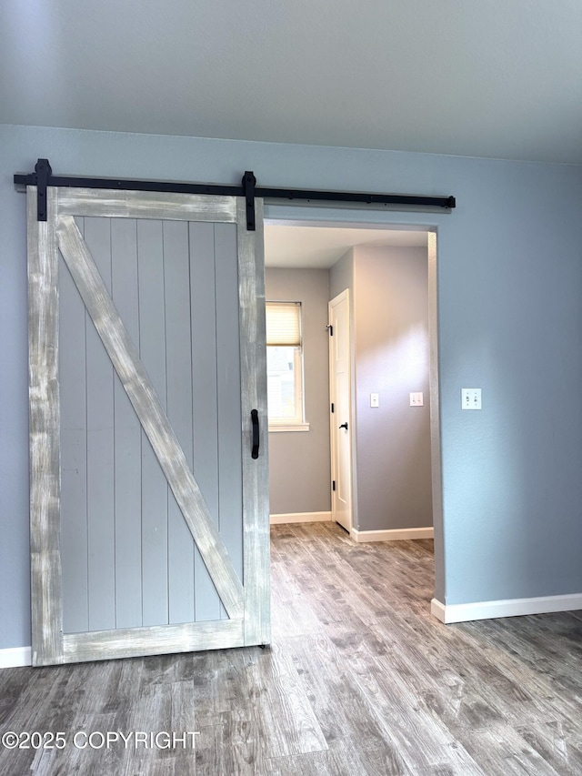 2321 Selief Ln, Kodiak, AK 99615 - unfurnished room with a barn door, wood finished floors, and baseboards