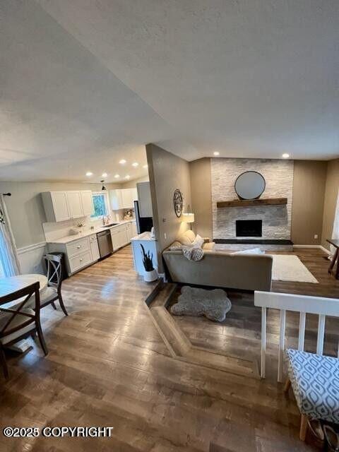 living area featuring a fireplace, recessed lighting, and light wood-style floors