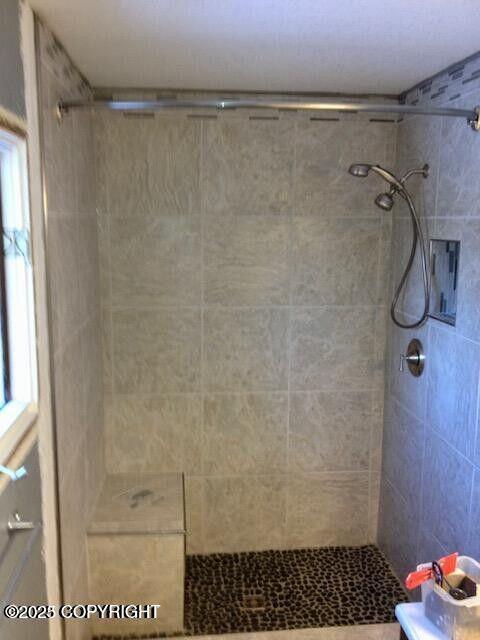 bathroom with tiled shower
