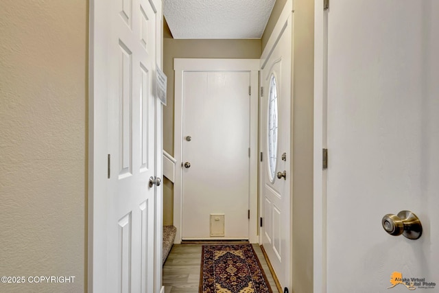 entryway featuring a textured ceiling and wood finished floors