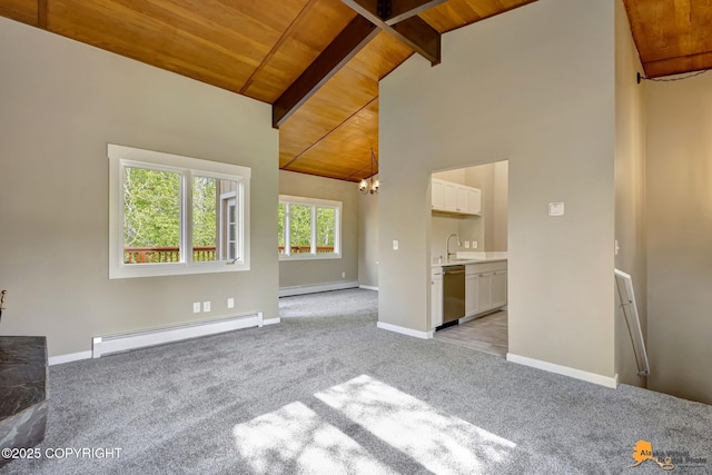 unfurnished living room featuring a baseboard heating unit, wood ceiling, light colored carpet, a sink, and a chandelier