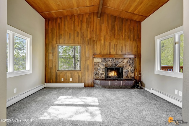 unfurnished living room with a baseboard radiator, wood ceiling, wooden walls, a fireplace, and carpet