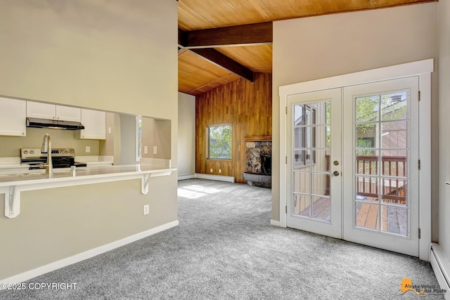 kitchen with under cabinet range hood, electric range, wooden ceiling, light colored carpet, and a kitchen breakfast bar