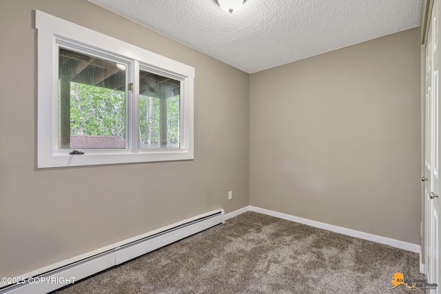 spare room featuring a baseboard heating unit, carpet, a textured ceiling, and baseboards