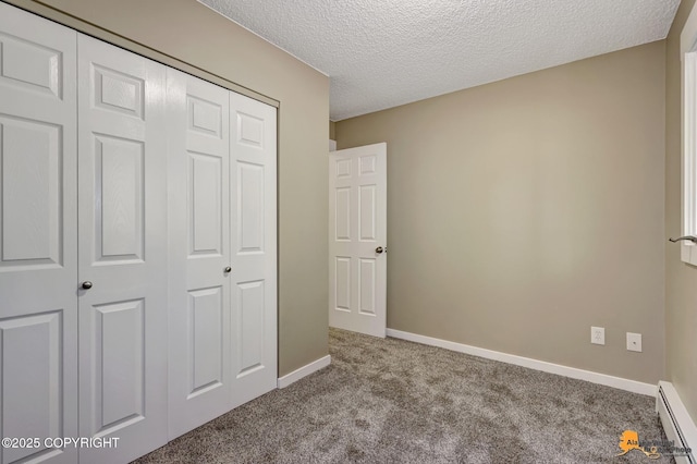 unfurnished bedroom featuring a baseboard radiator, carpet flooring, a closet, a textured ceiling, and baseboards