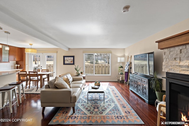 living area featuring a lit fireplace and dark wood-type flooring