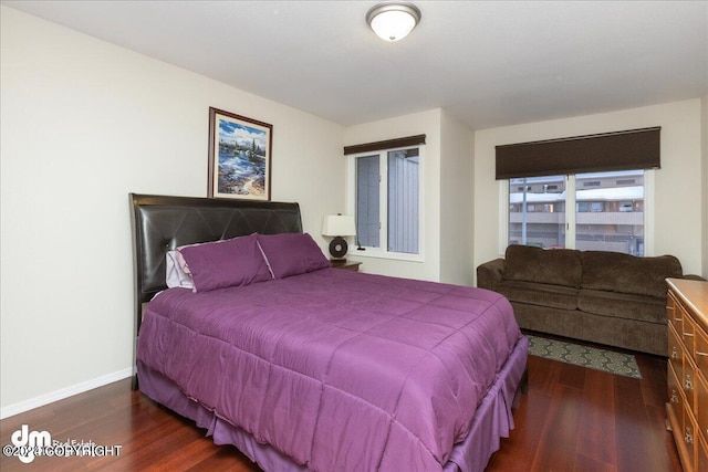 bedroom with dark wood finished floors and baseboards