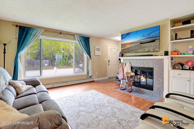 2816 Leighton St, Anchorage, AK 99517 - living area featuring a baseboard heating unit, a tile fireplace, wood finished floors, and a textured ceiling
