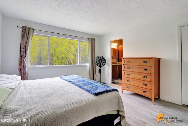 2816 Leighton St, Anchorage, AK 99517 - bedroom with light wood-type flooring, a textured ceiling, and ensuite bathroom