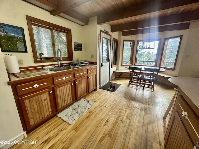 1581 Jade Dr, Homer, AK 99603 - kitchen with a sink, plenty of natural light, light wood-style flooring, brown cabinets, and wooden ceiling with exposed beams