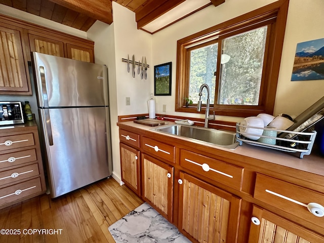 1581 Jade Dr, Homer, AK 99603 - kitchen featuring appliances with stainless steel finishes, a sink, brown cabinets, light wood-style flooring, and wooden ceiling