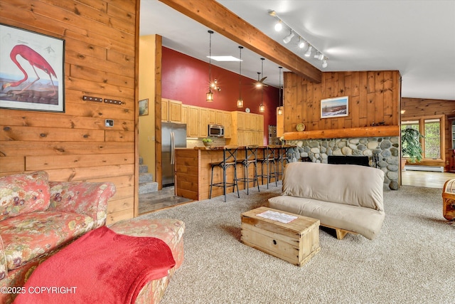 26266 Vallihi Cir, Eagle River, AK 99577 - living area with wood walls, light colored carpet, beamed ceiling, a fireplace, and high vaulted ceiling