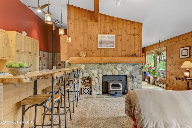 26266 Vallihi Cir, Eagle River, AK 99577 - living room with wood walls, vaulted ceiling, carpet floors, a wood stove, and baseboard heating
