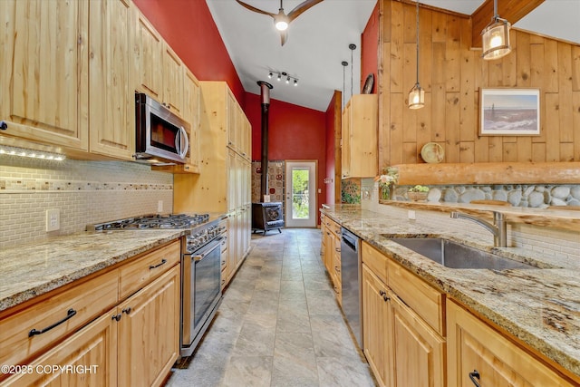 26266 Vallihi Cir, Eagle River, AK 99577 - kitchen featuring stainless steel appliances, a sink, a wood stove, tasteful backsplash, and light stone countertops