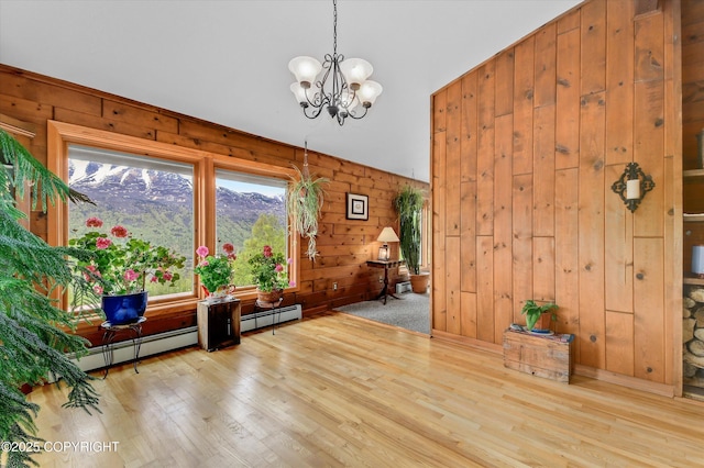 26266 Vallihi Cir, Eagle River, AK 99577 - dining space with wood finished floors, a chandelier, wooden walls, and a baseboard radiator