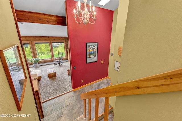 26266 Vallihi Cir, Eagle River, AK 99577 - foyer featuring stone tile flooring, a chandelier, baseboards, and beamed ceiling