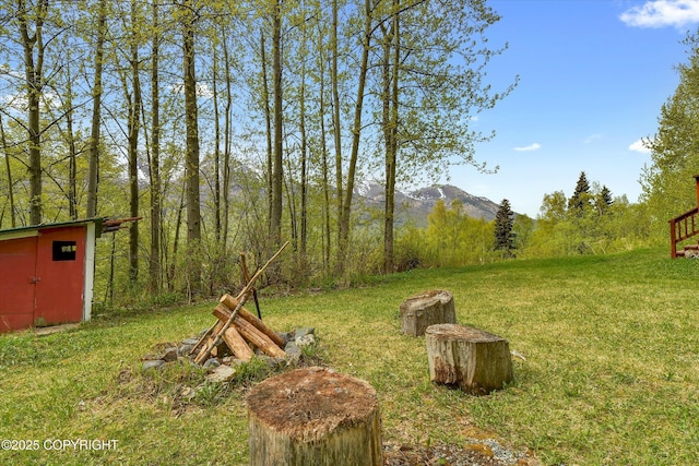 26266 Vallihi Cir, Eagle River, AK 99577 - view of green lawn with a storage shed, an outbuilding, and a mountain view