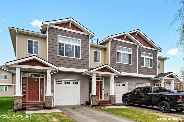 1473 Shallow Pool Dr # J1, Anchorage, AK 99504 - view of front of property featuring a garage, asphalt driveway, and stone siding