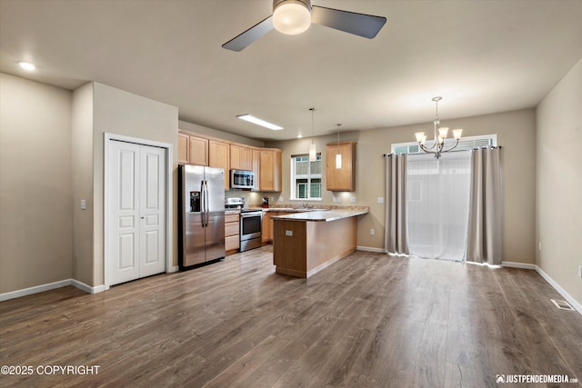 1473 Shallow Pool Dr # J1, Anchorage, AK 99504 - kitchen with appliances with stainless steel finishes, a peninsula, a chandelier, dark wood-style floors, and baseboards