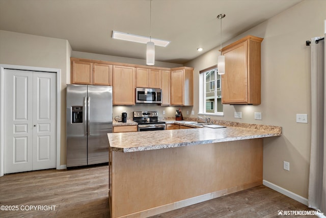 1473 Shallow Pool Dr # J1, Anchorage, AK 99504 - kitchen with appliances with stainless steel finishes, a peninsula, light brown cabinets, light wood-style floors, and light countertops