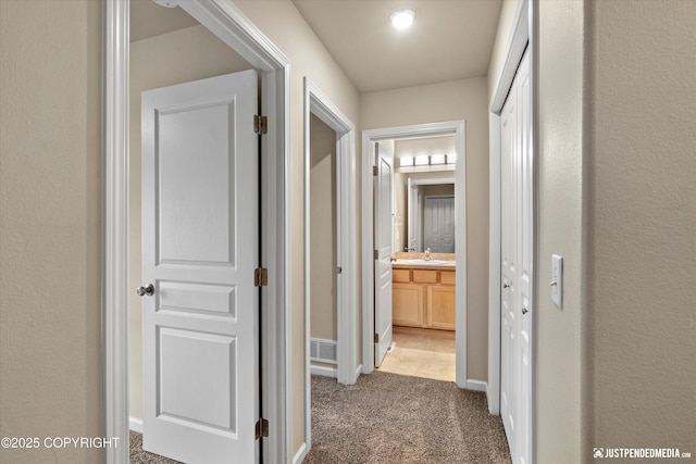 1473 Shallow Pool Dr # J1, Anchorage, AK 99504 - corridor featuring light colored carpet, a sink, and baseboards