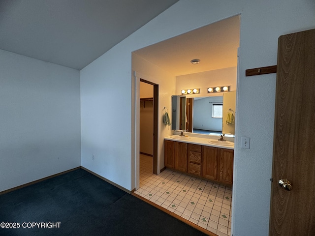 33325 Vinewood Ln, Seward, AK 99664 - bathroom with double vanity, a walk in closet, and baseboards