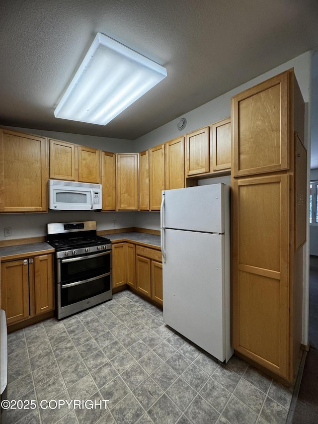 33325 Vinewood Ln, Seward, AK 99664 - kitchen featuring white appliances, a textured ceiling, and brown cabinetry