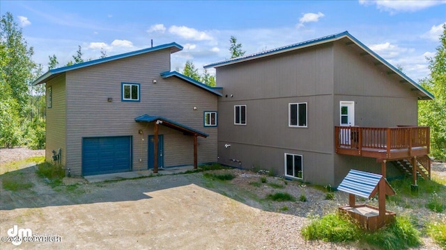 14184 W Jojoba Rd, Big Lake, AK 99623 - back of house with a deck, a garage, dirt driveway, and stairs