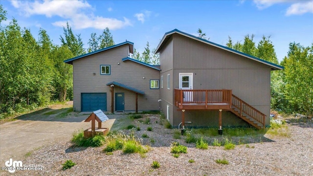 14184 W Jojoba Rd, Big Lake, AK 99623 - back of house with an attached garage, a deck, driveway, and stairway
