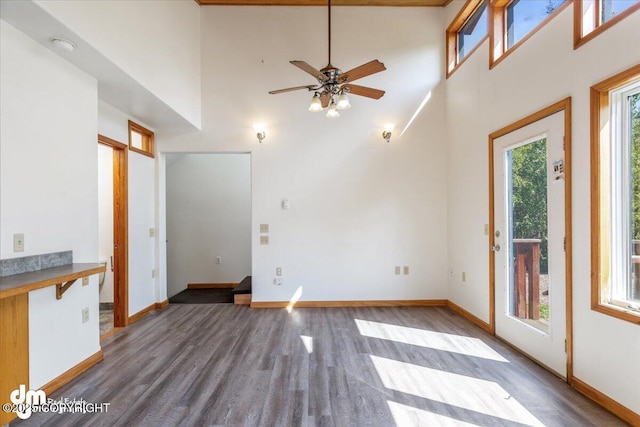14184 W Jojoba Rd, Big Lake, AK 99623 - unfurnished living room with wood finished floors, a high ceiling, baseboards, and a ceiling fan