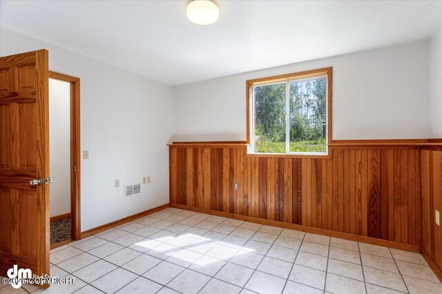 14184 W Jojoba Rd, Big Lake, AK 99623 - unfurnished room featuring a wainscoted wall, light tile patterned floors, and wood walls