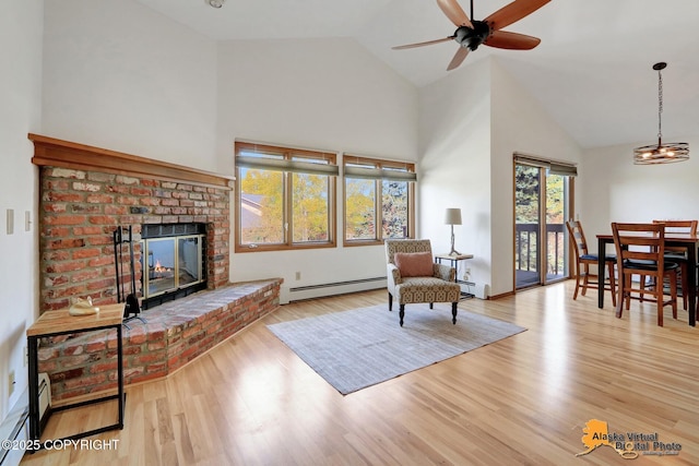 4230 Woronzof Dr # D, Anchorage, AK 99517 - living room with a baseboard heating unit, high vaulted ceiling, a brick fireplace, a ceiling fan, and wood finished floors