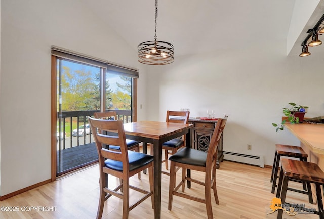 4230 Woronzof Dr # D, Anchorage, AK 99517 - dining room featuring a baseboard heating unit, light wood-type flooring, lofted ceiling, a chandelier, and rail lighting