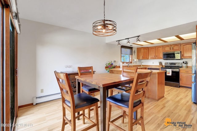 4230 Woronzof Dr # D, Anchorage, AK 99517 - dining area featuring a baseboard heating unit, light wood-type flooring, track lighting, and a chandelier