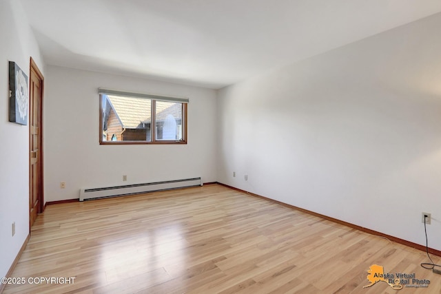 4230 Woronzof Dr # D, Anchorage, AK 99517 - empty room featuring a baseboard heating unit, light wood finished floors, and baseboards