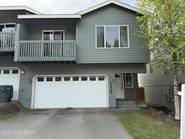 view of front of property with a garage, a balcony, and asphalt driveway