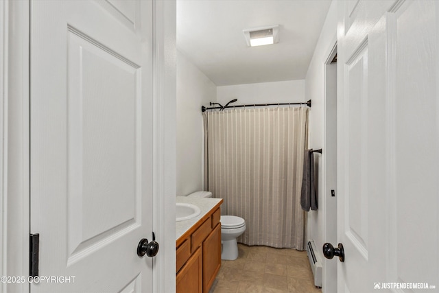 full bath with vanity, toilet, baseboard heating, and a shower with shower curtain