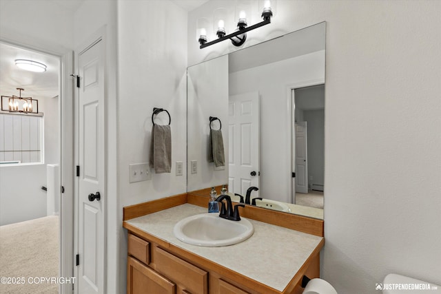 bathroom featuring a chandelier, vanity, baseboard heating, and toilet