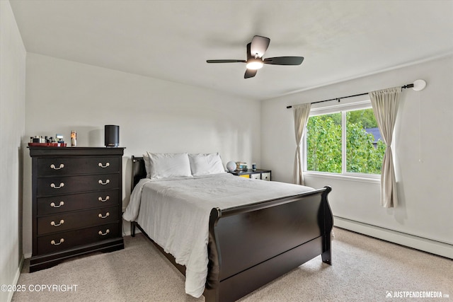 bedroom featuring light carpet, a baseboard heating unit, and a ceiling fan